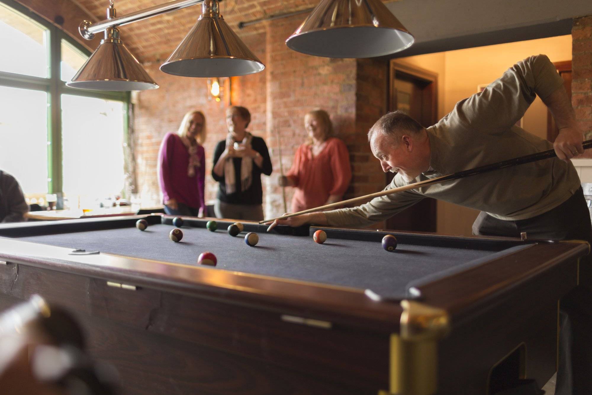 A group of friends playing pool in a bar